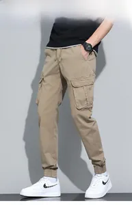 Detail of khaki cargo pants featuring large side flap pockets and adjustable drawstring waist