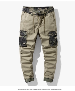 Close-up of khaki cargo pants featuring camouflage拼接 accents and drawstring waistband