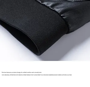 Detail of black faux leather jacket featuring elastic ribbed hem and premium grain texture