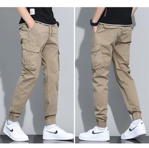 Detail view of khaki cotton cargo pants featuring side utility pockets and ribbed ankle cuffs