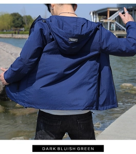 Détail de la veste anti-UV à capuche avec étiquette tissée NEW FASHION sur le dos