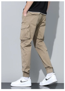Detail view of khaki cotton twill cargo pants with functional side flap pockets and elastic cuffs