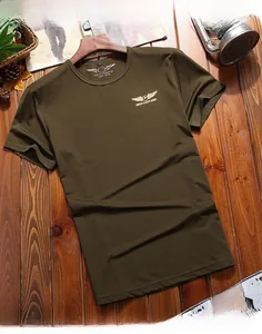 Detail of army green cotton t-shirt featuring wing logo print on brown wood background