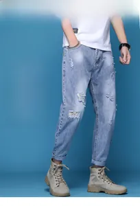 Détail de la texture denim bleu clair et accents déchirés sur ce jean fuselé décontracté