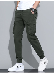 Detail view of dark green men's cargo joggers with side pockets and ribbed ankle cuffs