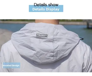 Détail d'une veste de protection solaire gris clair avec capuche et logo au dos