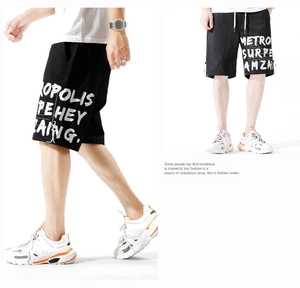 Détail de short cargo noir avec imprimé graffiti blanc et cordon de serrage réglable