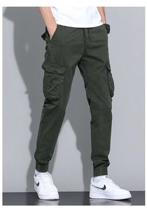 Detail of army green cargo pants featuring large side pockets and drawstring waist