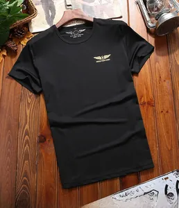 Detail of army green cotton t-shirt with gold wing star logo on a vintage wooden background