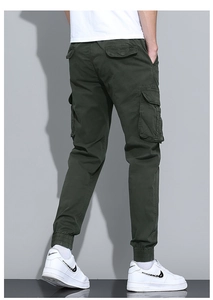 Detail view of olive green cargo pants showing side flap pockets and elastic cuffs on model