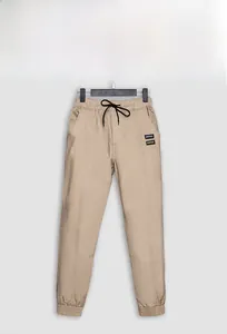 Detail of khaki cargo pants featuring drawstring waist and reinforced stitching on side pockets