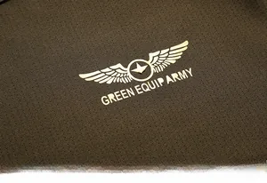 Close-up of olive green breathable honeycomb fabric with a golden military star logo