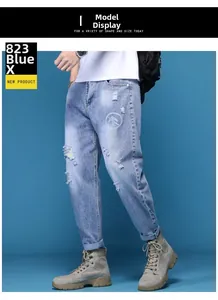 Détail du jean bleu clair délavé avec imprimé géométrique sur la cuisse pour homme