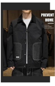 Detailed view of black utility jacket featuring gray denim patch pockets and metal buttons