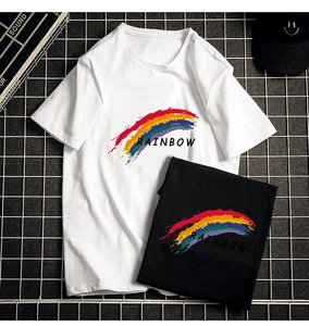 Flat lay of black and white cotton T-shirts with rainbow print on a metal mesh background