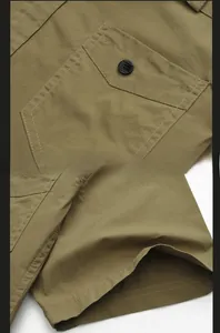 Close-up of khaki cotton twill shirt featuring a flap chest pocket and buttoned cuff detail
