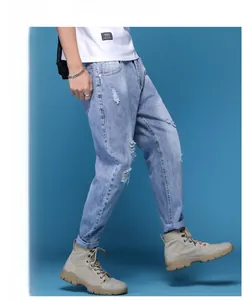 Vue détaillée du jean bleu clair délavé avec texture denim déchirée et détails effilochés