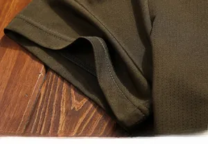Detail of olive green t-shirt sleeve with double-needle stitching and breathable mesh fabric