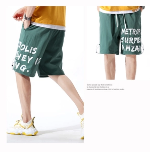 Détail du short cargo vert foncé avec imprimé graffiti blanc et poches latérales