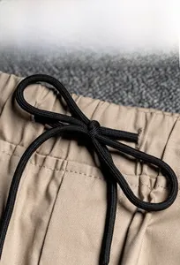 Close-up of khaki cargo pants featuring an elastic waist with black adjustable drawstring