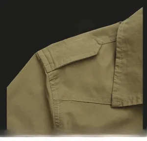 Detail view of military-style cotton shirt featuring buttoned epaulets and double stitching