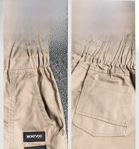 Detail view of khaki cotton cargo pants featuring elastic waist and large side pockets