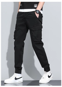 Detail of men's black cargo pants showing large side flap pockets and ribbed cuffs
