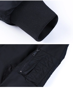 Detail of ribbed cuffs and utility sleeve pocket with zipper on a black MA1 bomber jacket