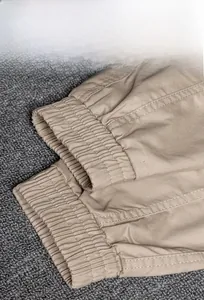 Detail of elastic ribbed cuffs on dark khaki joggers showing high-quality twill fabric
