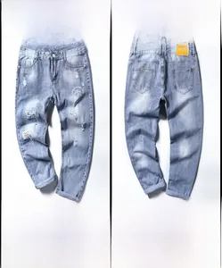 Vue détaillée du jean bleu clair délavé avec moustaches de chat et finitions déchirées