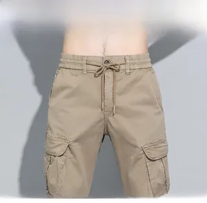 Detail of khaki cargo pants featuring elastic drawstring waist and flap side pockets