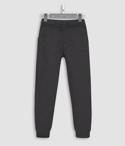 Detail of black jogger pants featuring elastic waistband and functional rear pockets