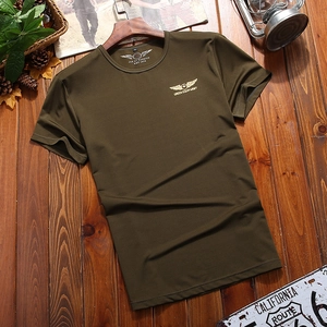 Army green military style cotton t-shirt with gold wing badge on dark wood background