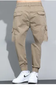 Detail of khaki cargo pants with elastic drawstring waist and side flap utility pockets