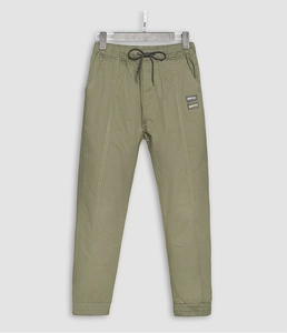 Detail of olive cargo joggers featuring elastic drawstring waist and leather logo patches