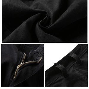 Detailed macro view of black twill fabric texture and bronze metal zipper on cargo shorts