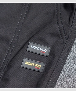 Detailed macro view of black twill fabric with parallel yellow and white Montvoo rubber tags
