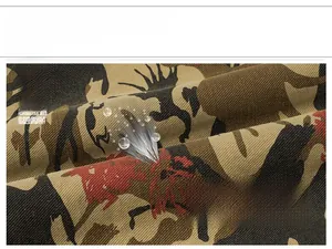Detailed macro view of 100% cotton camouflage fabric showing durable twill weave texture
