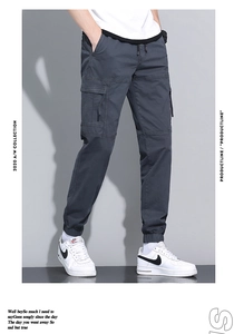 Detailed macro view of dark grey cotton cargo pants with elastic drawstring waist and pockets