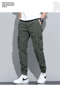 Detailed close-up of army green cargo pants featuring zip pockets and drawstring cuffs