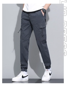 Detail of dark grey cargo pants with side flap pockets and elastic ribbed cuffs