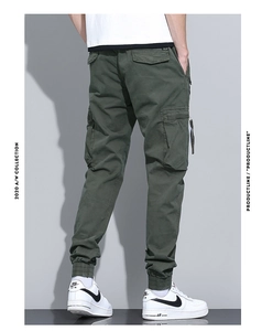 Detail view of olive green cargo pants featuring functional pockets and ribbed ankle cuffs