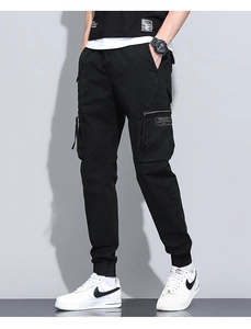 Detailed view of cargo pocket with zipper and label on men's black joggers