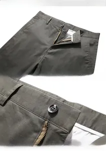 Detailed macro view of the waist, metal zipper, and button on dark grey men's pants