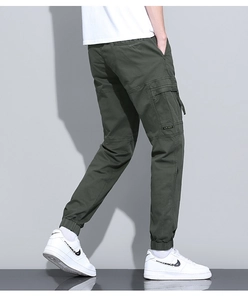 Detail view of military green cargo pants featuring side flap pockets and cuffed ankles