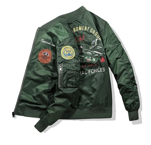 Detailed view of military embroidery and patches on a dark green bomber jacket