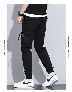 Detail of black cargo pants featuring multi-pocket design and ribbed elastic cuffs
