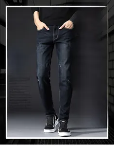 Detail of dark blue slim fit jeans showing whiskering and distressed repair effects