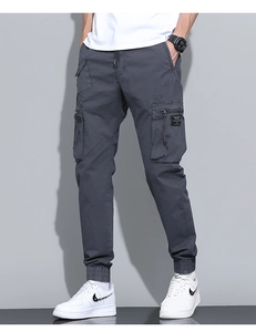 Detail of dark grey cargo pants with multiple utility pockets and tactical drawstring