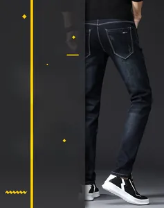 Detail view of dark indigo slim fit men's jeans featuring red label on back pocket